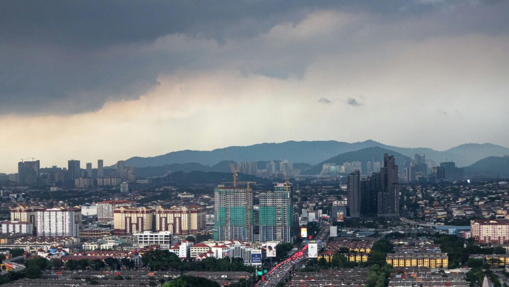 Aerial view of Subang Jaya, Malaysia with storm clouds and urban skyline.